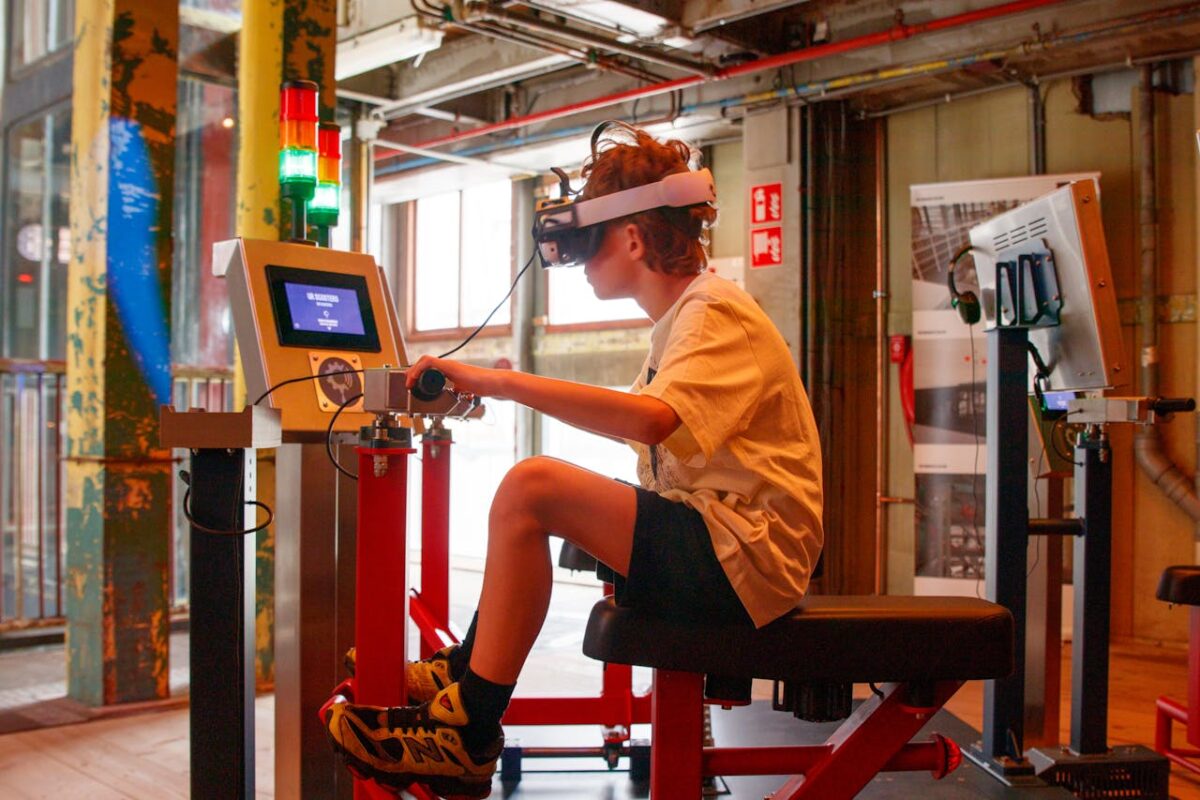 A teenager using a VR headset and control panel in an industrial-style interior setting.